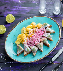 Herring with new potatoes. Lightly salted herring with fried young potatoes, rye bread croutons and pickled onions