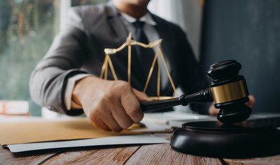 Business and lawyers discussing contract papers with brass scale on desk in office. Law, legal services, advice, justice and law concept picture with film grain effect