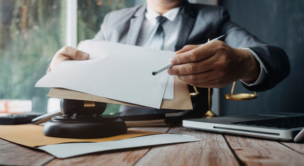 Business and lawyers discussing contract papers with brass scale on desk in office. Law, legal services, advice, justice and law concept picture with film grain effect