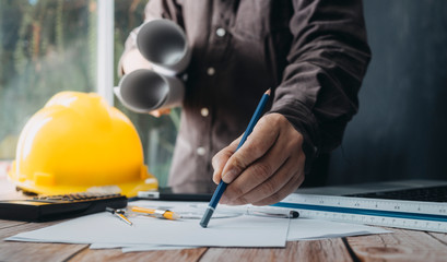 Two colleagues discussing data working and tablet, laptop with on on architectural project at construction site at desk in office