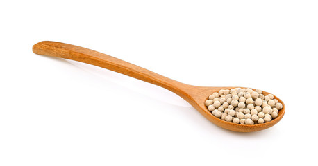 Pepper seeds in a wooden spoon on white background