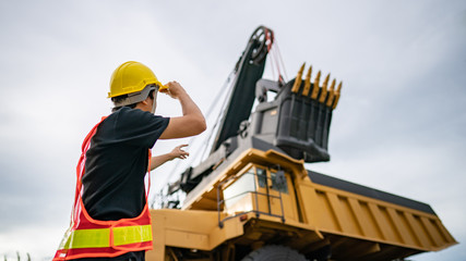 Worker in lignite or coal mining with the truck transporting coal.