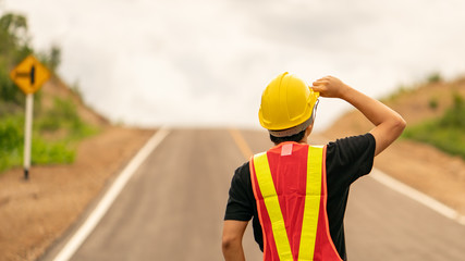Engineer wearing yellow helmet for safety with the road background.