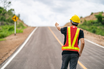 Obraz premium Engineer wearing yellow helmet for safety with the road background.