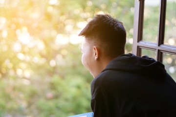 close up young man looking out of window