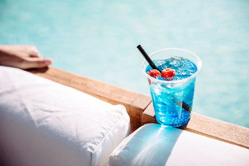 A blue cocktail poolside at a resort