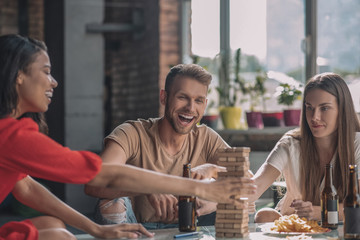 Friends having fun while playing Jenga at the party