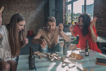 Group of friends having their Jenga tower fallen
