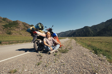 Obraz premium Young woman travelling by scooter in mountains road