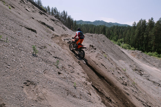 Rider climbing sand mountain on  off-road cross motorcycle