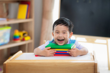 Asian student happy after back to school and smile in his class room in preschool - obrazy, fototapety, plakaty