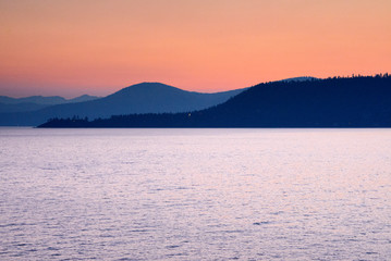 sunrise over lake Tahoe with different shaded mountains and orange red sky