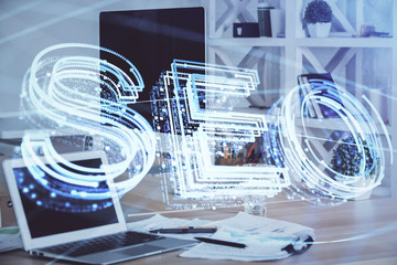Multi exposure of table with computer and seo drawing hologram. Search optimization concept.