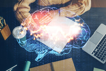 Multi exposure of writing hand on background with brain hologram. Concept of learning.