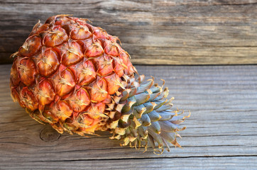 Fresh ripe pineapple fruit on old wooden table.Ananas comosus.Healthy eating, diet or vegan food concept.Selective focus.