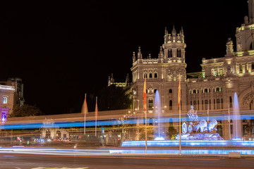 Fototapeta na wymiar Night photography of lines of light drawn by the traffic of vehicles next to the Fuente de Cibeles and the Madrid City Council