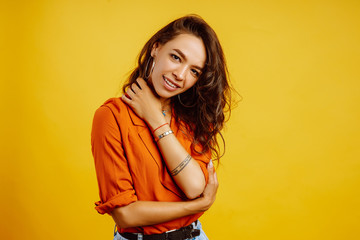 Portrait of young woman in a shirt and jeans. African American woman posing on yellow background. Fashion, glamour and lifestyle concept.