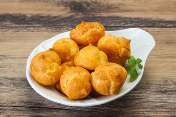 Sweet tasty profiteroles heap in the bowl