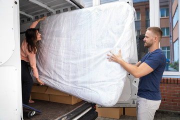 Couple Unloading Mattress From Van Or Truck