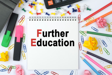 On the table is a calculator, diary, markers, pencils and a notebook with the inscription - Further Education