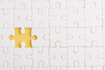 Top view flat lay of paper plain white jigsaw puzzle game texture incomplete or missing piece,...