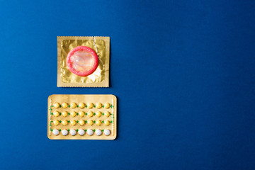 World sexual health or Aids day, condom on wrapper pack and contraceptive pills blister hormonal...