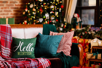 Interior room with brick walls and a window, Christmas tree, sofa and table with christmas-style things
