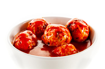 Roast meatballs with sauce on white background
