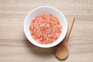 Himalayan pink salt in ceramic cup on wooden table