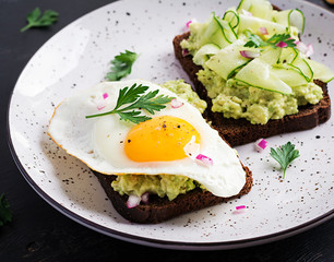 Healthy breakfast. Sandwich with avocado guacamole, cucumber and fried egg,   for healthy breakfast or snack.
