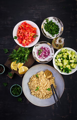 Tabbouleh salad. Traditional middle eastern or arab dish. Levantine vegetarian salad with parsley, mint, bulgur, tomato. Ingredients. Top view