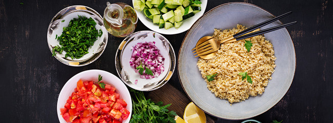 Tabbouleh salad. Traditional middle eastern or arab dish. Levantine vegetarian salad with parsley, mint, bulgur, tomato. Ingredients. Top view