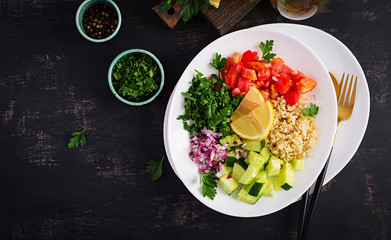 Tabbouleh salad. Traditional middle eastern or arab dish. Levantine vegetarian salad with parsley, mint, bulgur, tomato. Top view