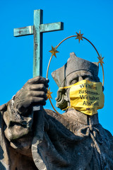 Statue des Heiligen Johannes von Nepomuk auf der Alten Mainbrücke in Würzburg mit Atemschutzmaske