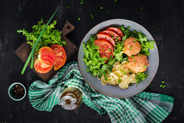Italian pasta. Farfalle with meatballs and salad on dark background. Dinner. Top view, overhead....