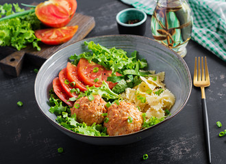 Italian pasta. Farfalle with meatballs and salad on dark background. Dinner. Slow food concept
