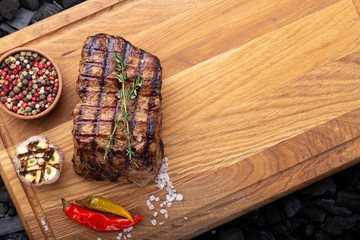 Juicy steak with vegetables on a wooden board.