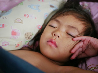 Little Asian baby girl, 2.5 years old, sleeping tight and resting her head on her hand comfortably