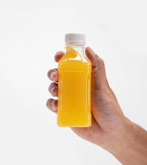 hand holding fruit juice on a plastic bottle product mockup