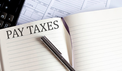 Notebook with Toolls and Notes about PAY TAXES