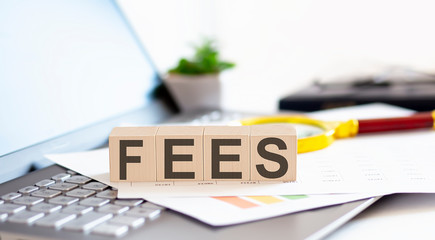 FEES Wooden cubes with letters on a laptop keyboard.