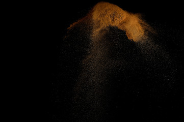 Sandy explosion isolated on black background. Abstract sand cloud.