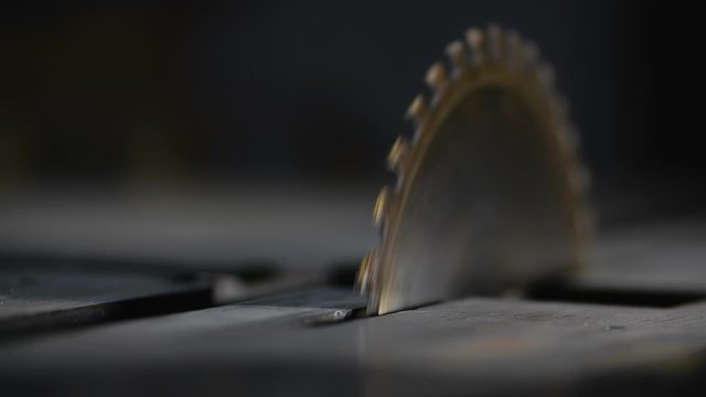Rotating a circular saw on a metal table in a woodworking workshop at a small furniture manufactory at 200 fps slow motion. Woodworking, joinery