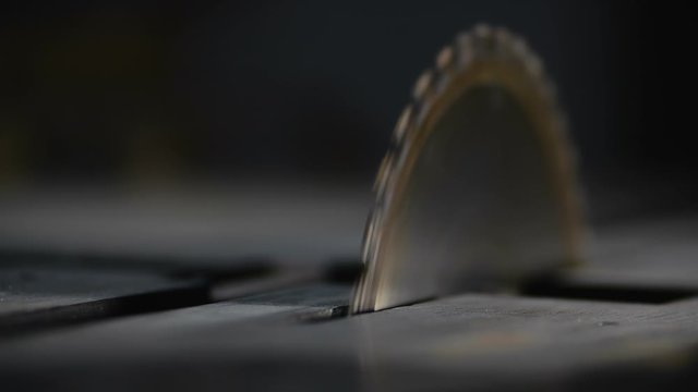Rotating a circular saw on a metal table in a woodworking workshop at a small furniture manufactory at 200 fps slow motion. Woodworking, joinery