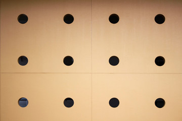 Yellow wall with many round holes