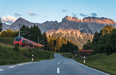 Rural mountain road near Mittenwald, Bavaria, Germany with Karwendel mountains on background at sunset. Idyllic mountain scene. 