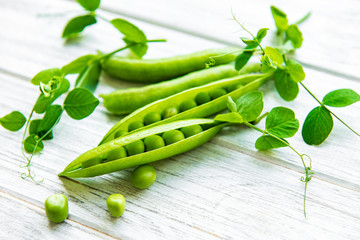 Green peas  on a white wooden background.  Healthy food background.