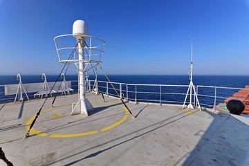 Ship structures, masts, antennas, funnel, ship wheelhouse against the blue sky and clouds. Vessel traveling at ocean. © masterskuz55