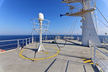 Ship structures, masts, antennas, funnel, ship wheelhouse against the blue sky and clouds. Vessel traveling at ocean. © masterskuz55