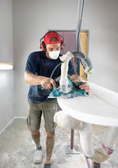 Surfboard Modeling Workshop - Man shaping a surfboard with a sander